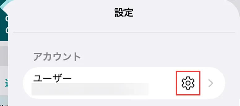 アプリのアカウント画面で設定ボタンの位置を示している