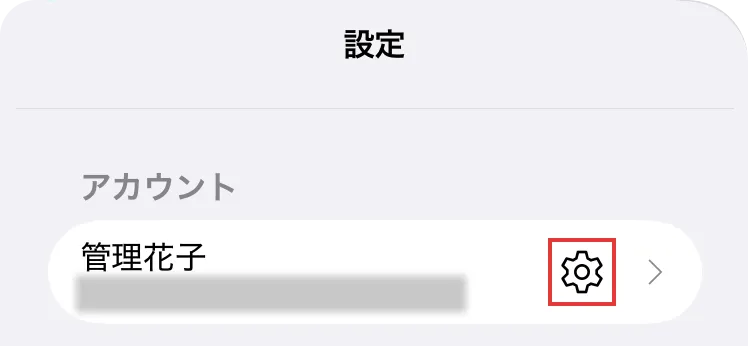 アプリのアカウント画面で設定ボタンの位置を示している